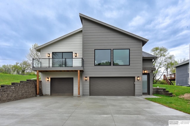contemporary house featuring an attached garage, driveway, and a balcony