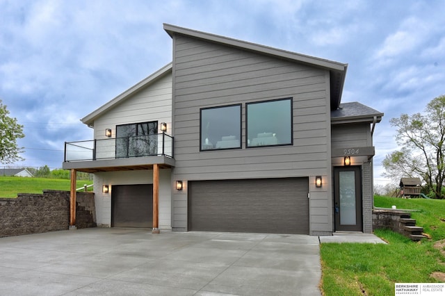modern home with a garage, a balcony, and driveway