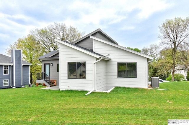 rear view of property with a yard and central AC