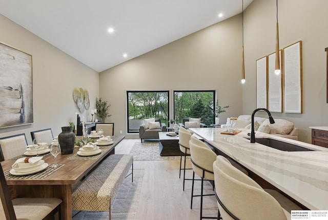 dining room featuring recessed lighting, high vaulted ceiling, and light wood finished floors