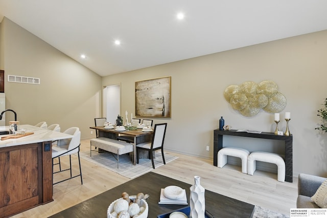 dining room with visible vents, lofted ceiling, light wood-style floors, baseboards, and recessed lighting