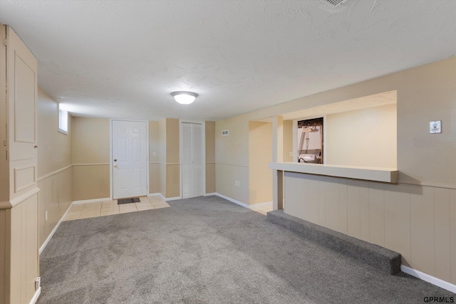 finished basement featuring light carpet