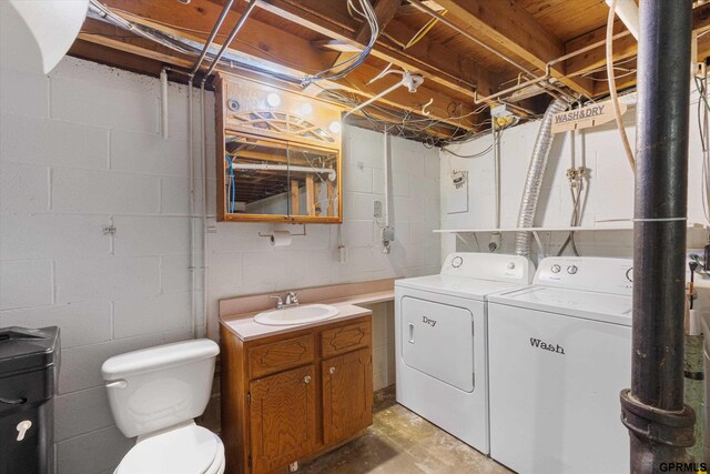 washroom with separate washer and dryer, a sink, and laundry area