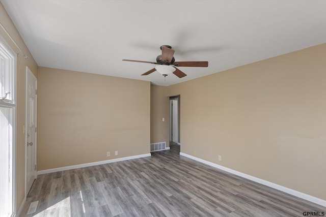 spare room featuring visible vents, baseboards, ceiling fan, and wood finished floors