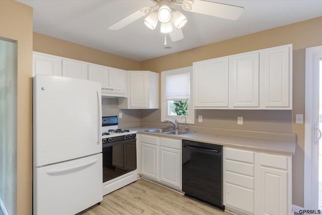 kitchen featuring freestanding refrigerator, a ceiling fan, black dishwasher, under cabinet range hood, and range with gas cooktop