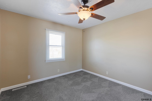 unfurnished room featuring baseboards, visible vents, ceiling fan, and dark colored carpet
