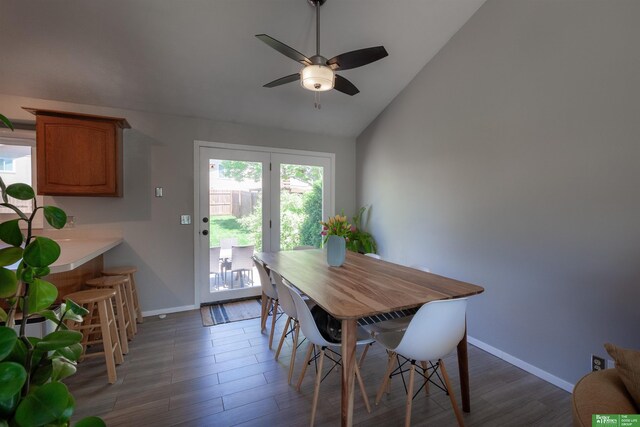dining room featuring baseboards, a ceiling fan, lofted ceiling, and wood finished floors