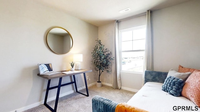 sitting room featuring carpet floors, baseboards, a wealth of natural light, and visible vents