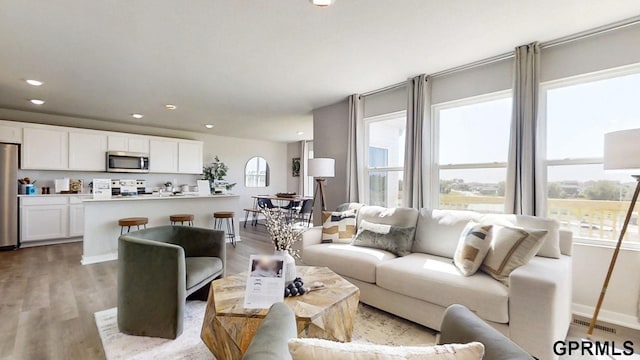 living room with light wood-style floors, recessed lighting, baseboards, and visible vents