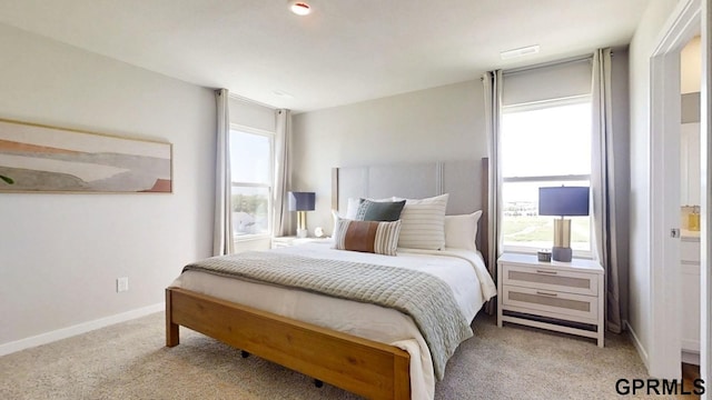 carpeted bedroom with baseboards and multiple windows