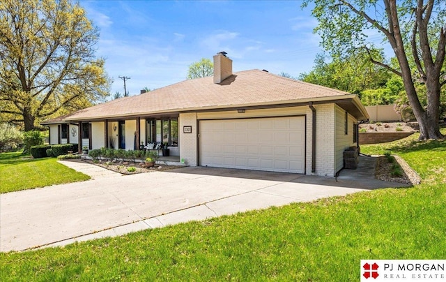 single story home with covered porch, a chimney, a front yard, brick siding, and an attached garage