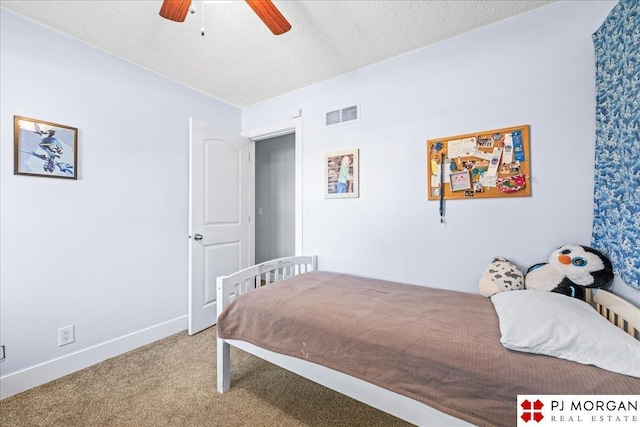 carpeted bedroom with baseboards, a ceiling fan, a textured ceiling, and visible vents
