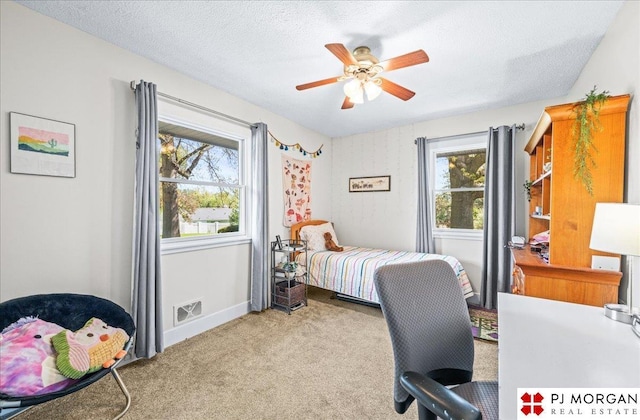 bedroom featuring a ceiling fan, a textured ceiling, visible vents, baseboards, and carpet flooring
