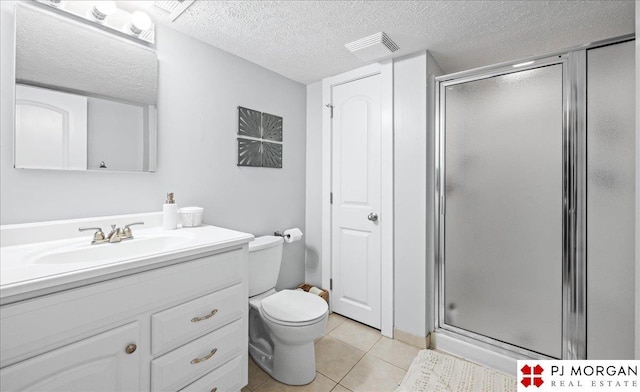 full bathroom with vanity, tile patterned flooring, a shower stall, and a textured ceiling