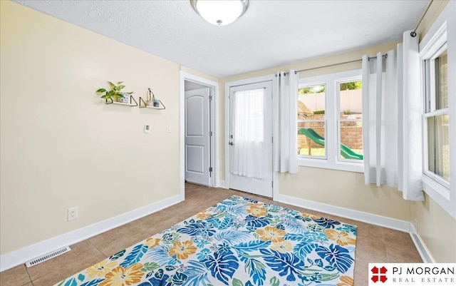foyer with baseboards, tile patterned floors, and visible vents