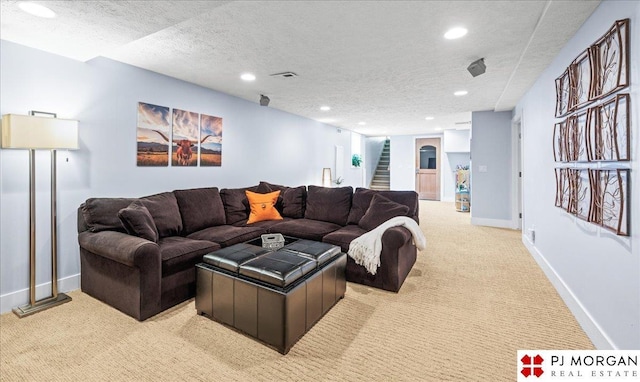living area with light colored carpet, recessed lighting, a textured ceiling, and stairway