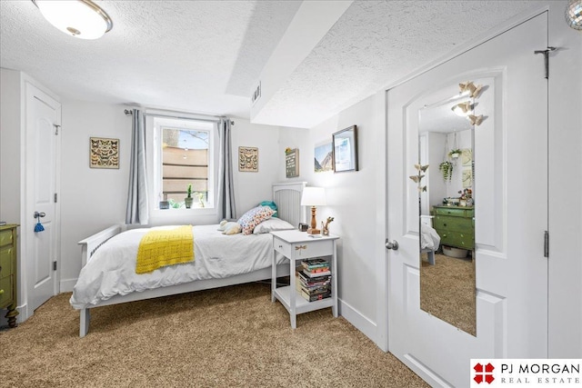 carpeted bedroom with a textured ceiling, visible vents, and baseboards