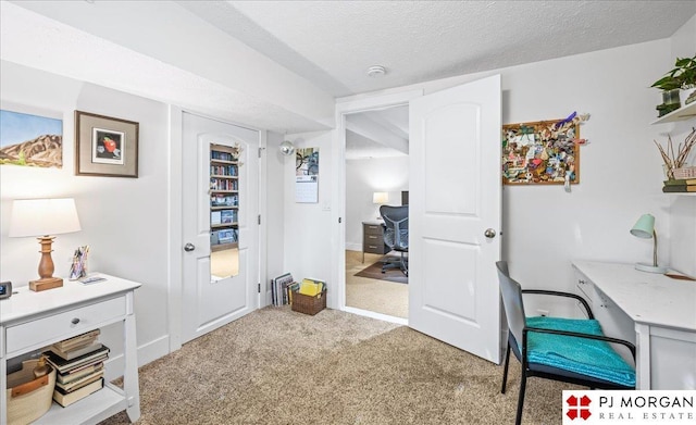 office featuring a textured ceiling, baseboards, and carpet