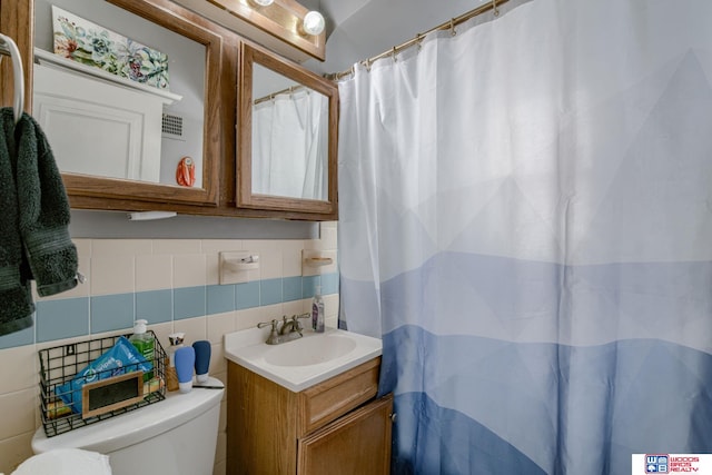 bathroom with tile walls, tasteful backsplash, curtained shower, vanity, and toilet