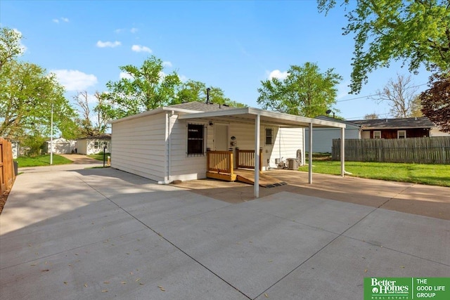 rear view of property with fence and concrete driveway