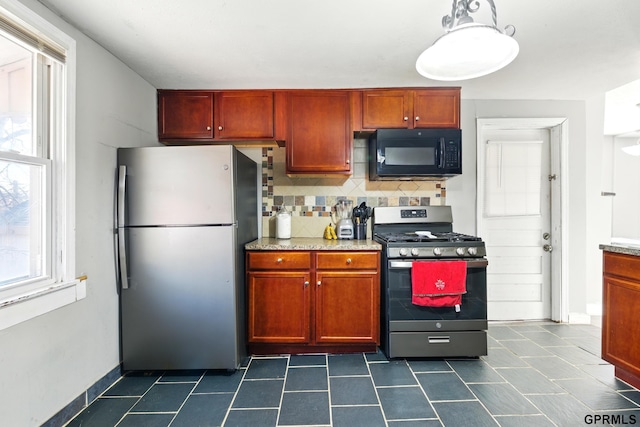 kitchen with decorative backsplash, light stone countertops, baseboards, dark tile patterned flooring, and appliances with stainless steel finishes