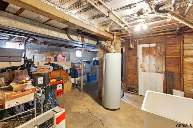 below grade area featuring water heater and wooden walls