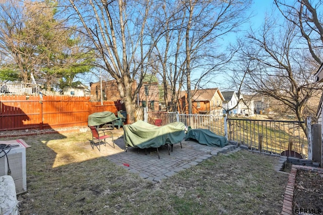 view of yard featuring central air condition unit, a fenced backyard, and a patio area