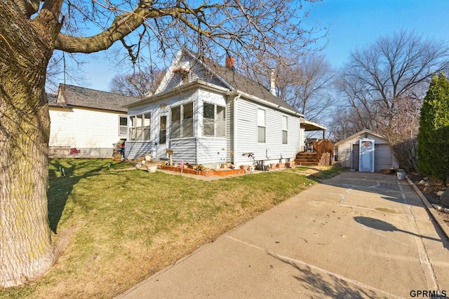 view of front of house featuring a chimney, a front yard, a garage, an outdoor structure, and concrete driveway