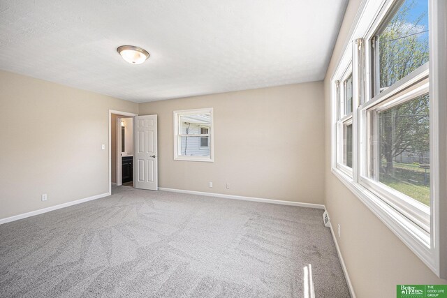 empty room featuring baseboards and carpet