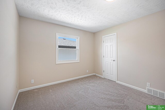 unfurnished room with baseboards, carpet flooring, a textured ceiling, and visible vents