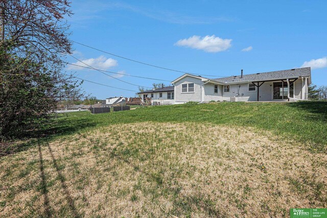 back of property with fence and a yard