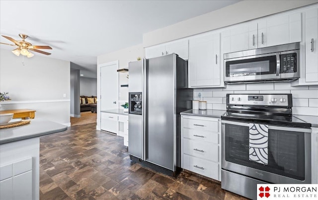kitchen featuring white cabinetry, a ceiling fan, appliances with stainless steel finishes, and decorative backsplash