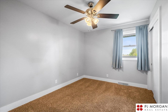 carpeted spare room with a ceiling fan, baseboards, and visible vents