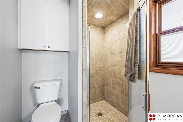 full bathroom featuring baseboards, toilet, and a shower stall