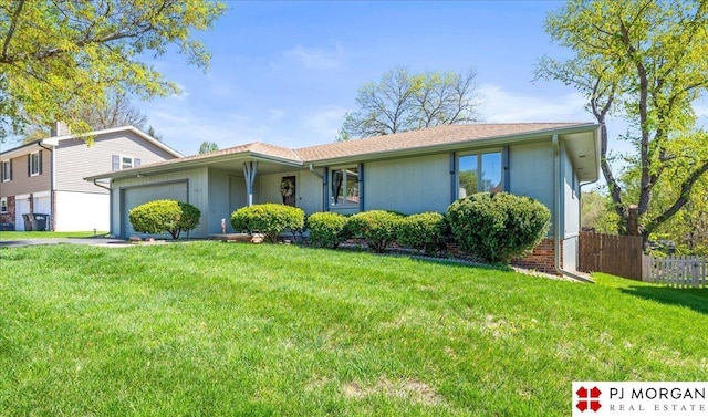 view of front of home featuring fence, a front yard, and a garage