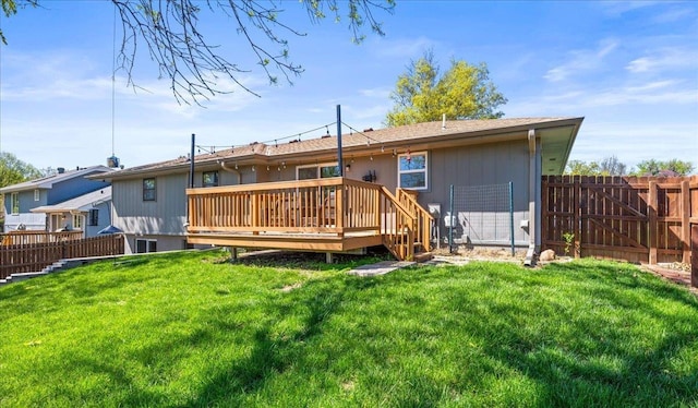 back of property featuring a yard, a wooden deck, and a fenced backyard