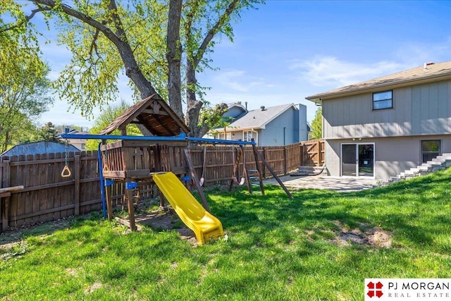 view of playground featuring a yard, a fenced backyard, and a patio area
