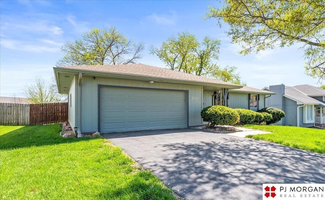 view of front of property with fence, a front yard, aphalt driveway, and a garage