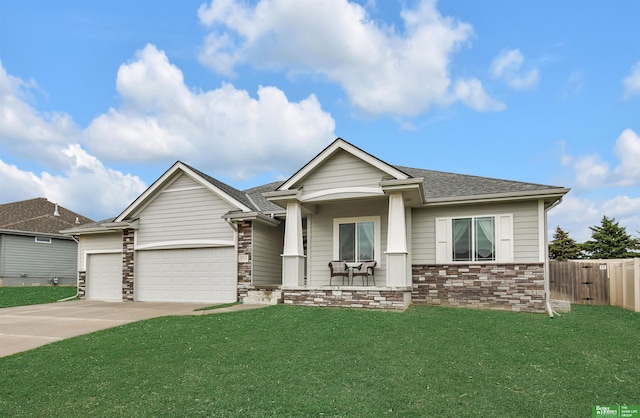 craftsman-style house with a garage, fence, a front yard, and concrete driveway