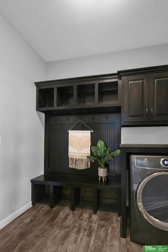 laundry room with washer / dryer, baseboards, cabinet space, and dark wood-type flooring