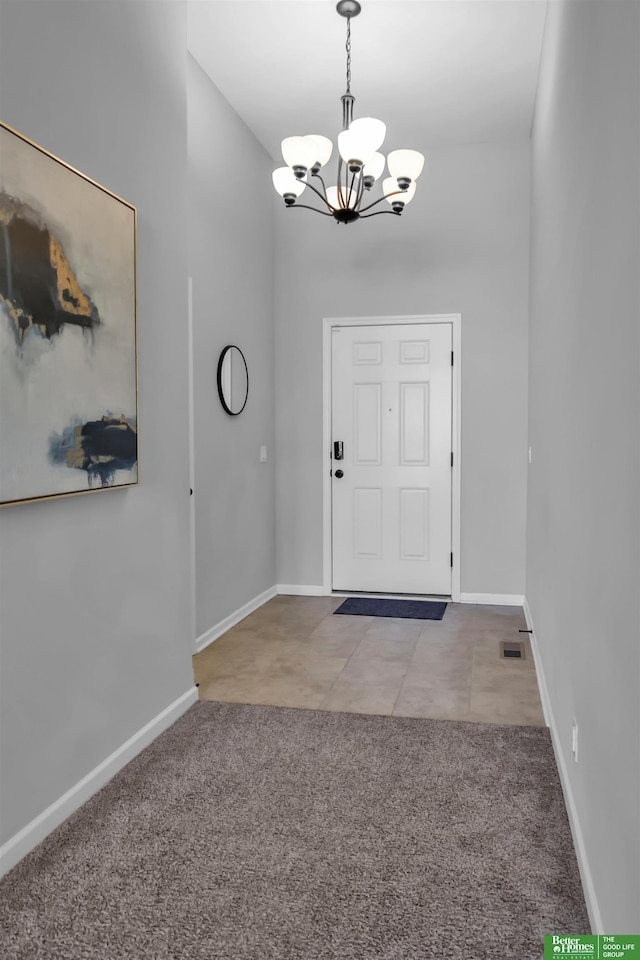 foyer with carpet floors, baseboards, a chandelier, and visible vents
