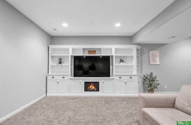 carpeted living area featuring baseboards, a lit fireplace, recessed lighting, and visible vents