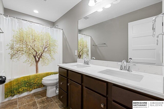 8230 Kilpatrick Pkwy, Bennington, NE 68007 - full bath featuring toilet, double vanity, and stone finish floors