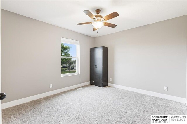 8230 Kilpatrick Pkwy, Bennington, NE 68007 - empty room featuring light colored carpet, baseboards, and ceiling fan
