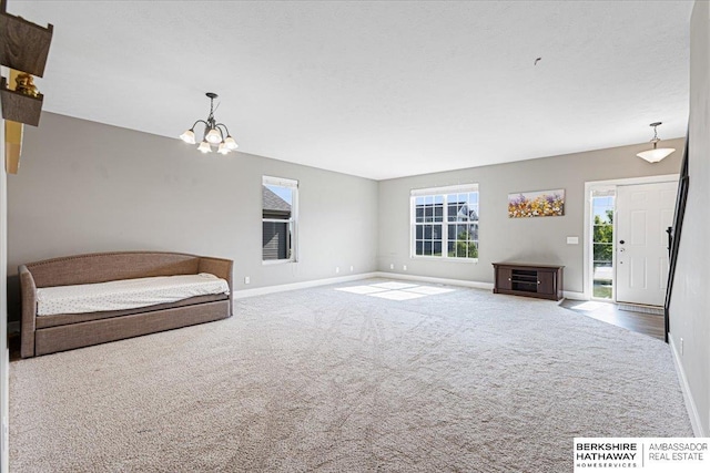 8230 Kilpatrick Pkwy, Bennington, NE 68007 - unfurnished living room featuring carpet floors, baseboards, and a chandelier