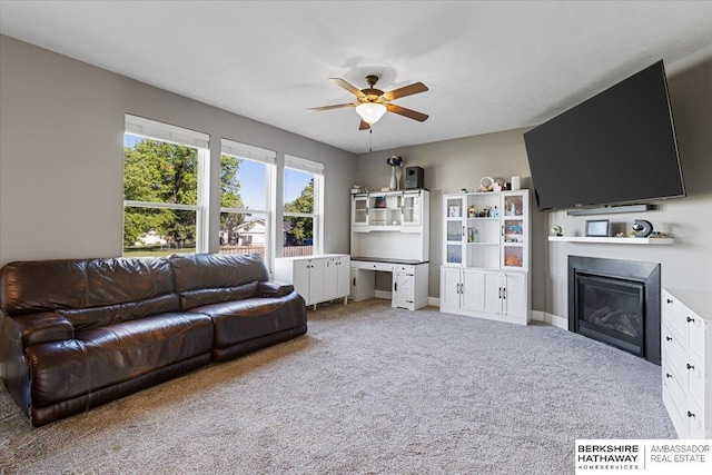 8230 Kilpatrick Pkwy, Bennington, NE 68007 - living area featuring a glass covered fireplace, a ceiling fan, carpet flooring, baseboards, and an office area