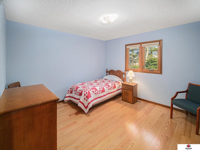 1521 Kingston Rd, Lincoln, NE 68506 - bedroom with baseboards, light wood-type flooring, and a textured ceiling