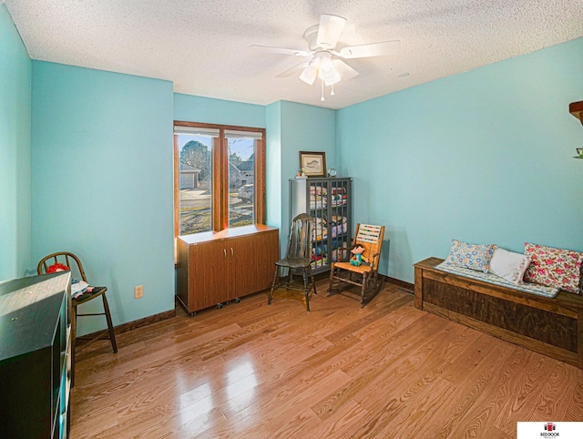 1521 Kingston Rd, Lincoln, NE 68506 - living area with baseboards, a ceiling fan, a textured ceiling, and light wood-style flooring