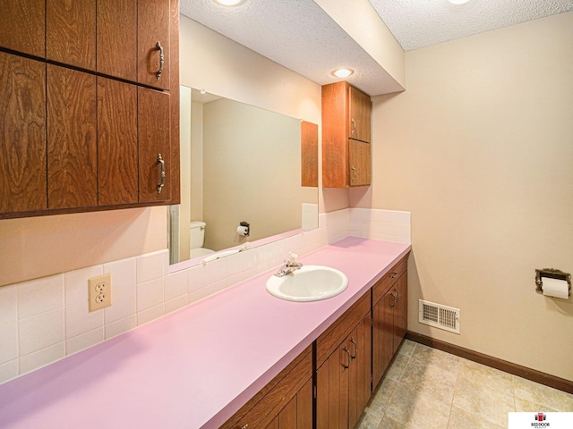 1521 Kingston Rd, Lincoln, NE 68506 - bathroom with toilet, a textured ceiling, baseboards, backsplash, and visible vents