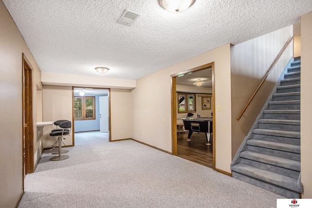 1521 Kingston Rd, Lincoln, NE 68506 - interior space with a textured ceiling, visible vents, stairway, baseboards, and carpet